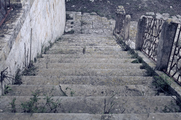 Fototapeta na wymiar Abandoned stairs, view from above. Worn-out stones, grass. 