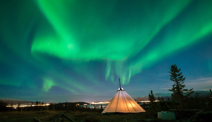 Traditional Sami reindeer-skin tents (lappish yurts) in Troms region of Norway .The polar lights in Norway .