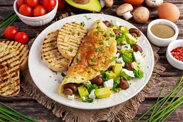 Mushroom, Feta Cheese egg Omelette witch Avocado, vegetables, lettuce, herbs and grilled bread.