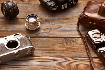 Vintage cameras and lenses on wooden background