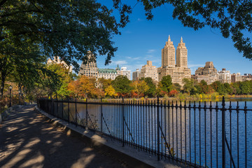 Upper West Side with colorful fall foliage across Jacqueline Kennedy Onassis Reservoir. Central Park West. Manhattan, New York City - obrazy, fototapety, plakaty