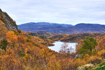 Tarn between fell sides covered with yellow and brown foliage in south west Norway