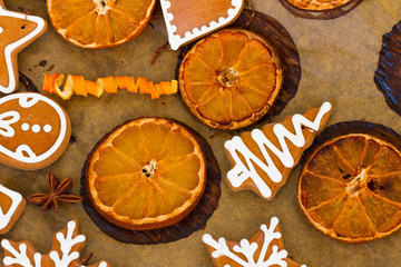christmas gingerbread cookies with orange slices on cooking paper close up
