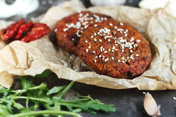 Potato burgers on baking paper om dark grey table. Still life of cooked batat burgers. Vegan food.  Close up.