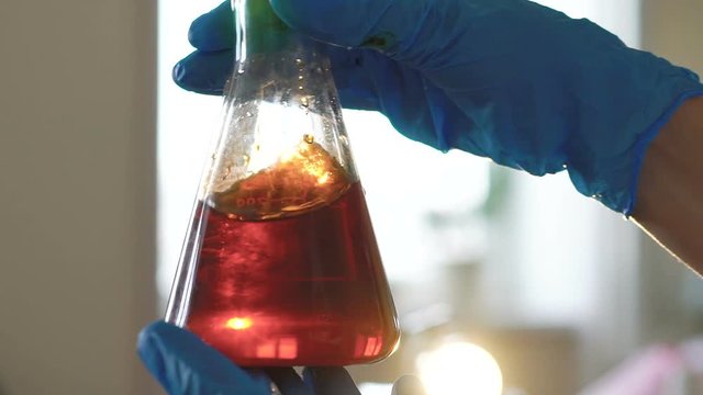 Young female chemist doing science experiment with chemicals
