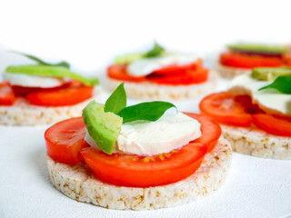Healthy food - sandwiches, rice crackers with tomato, avocado and mozzarella cheese