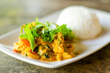Thai food,Stir fried squid with yellow curry and cooked rice on white dish