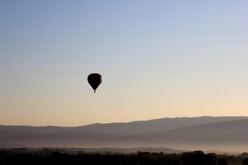 Hot air balloon in the morning twilight over the fields of france