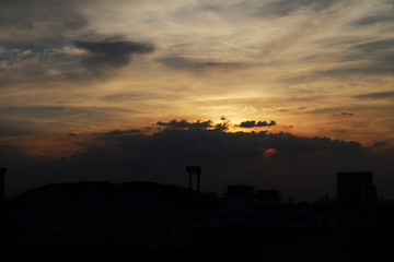 Beautiful sky at top view building, golden dramatic sky with cloud on black cloudy, Sunset in the city, Amazing sunset over building on the town, Storm cloud sky over city , Cloudscape.