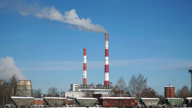 Thermal power plant or a factory with Smoking chimneys. Polluting smoke into the clear blue sky.
