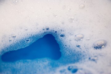 Abstract background of soap foam, suds, shower. Blue background. soft focus, macro view