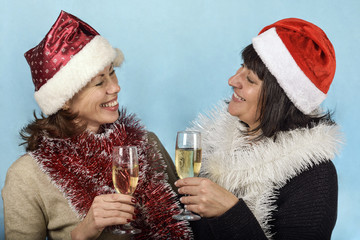 Girl in Santa Claus hats and champagne