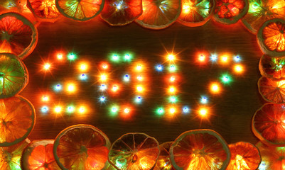 2017 new year on wooden desk table background. Number from colorful bright lights lamp bulb. Frame border dried oranges. Conceptual for congratulation winter holidays greeting cards.