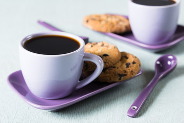 Purple coffee cup with saucer and spoon on light blue background