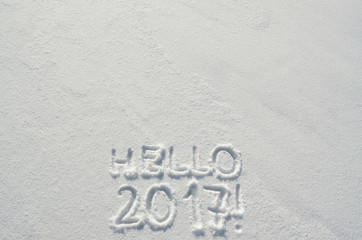 Hello 2017 text letters handwritten on flat snow surface. Empty space for copy, lettering. New year holiday postcard, greeting card template.