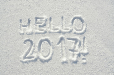 Hello 2017 text letters handwritten on flat snow surface. New ye