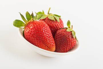 Fresh strawberries in plate on white background