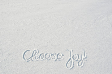 Fototapeta na wymiar Beautiful Choose Joy letters calligraphy handdrawn on flat snow surface. Nice Christmas holiday square postcard, greeting card template. Empty space for copy, text, lettering.