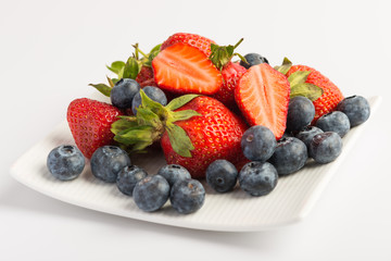 Fresh strawberries and blueberries on white background