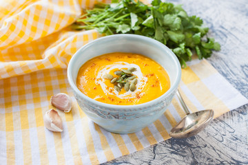 pumpkin cream soup in a bowl on a table, selective focus