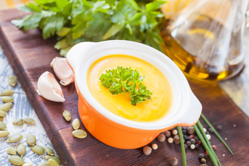 pumpkin cream soup in a bowl on a table, selective focus
