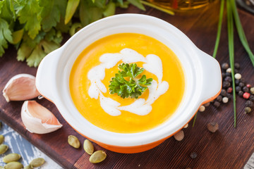 pumpkin cream soup in a bowl on a table, selective focus