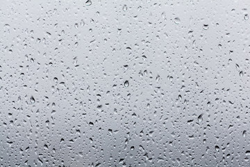 Rain drops on window glasses surface with cloudy background . Na