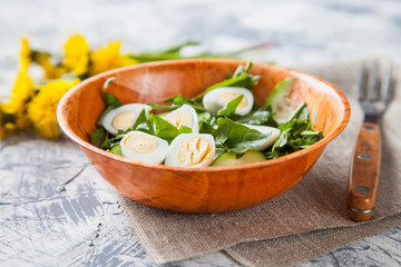 green salad with egg and dandelions in a bowl, selective focus