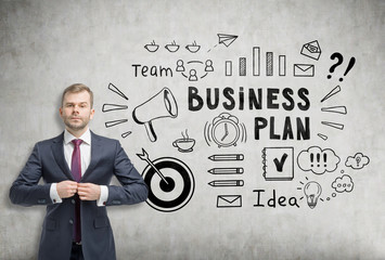 Businessman buttoning his suit near a business plan sketch