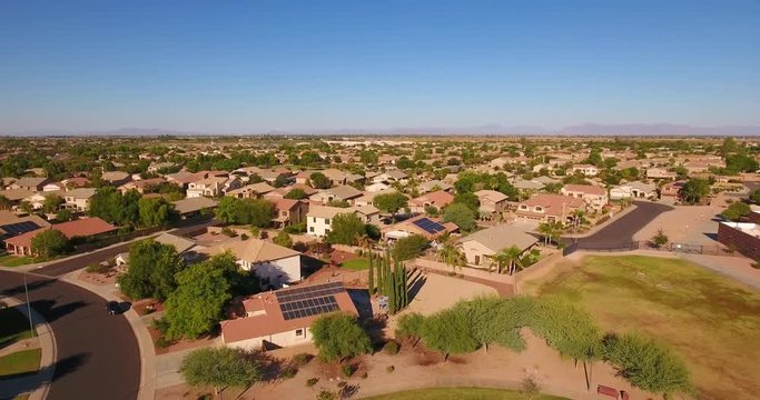 A flyover aerial establishing shot of a typical Arizona residential neighborhood. The Superstition Mountain range in the distance. Phoenix suburb.	 	