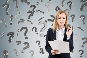 Blond woman with documents and falling question marks