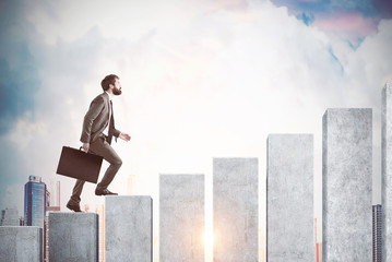 Side view of a businessman climbing a graph