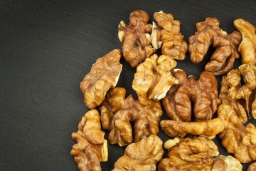 Closeup of big shelled walnuts pile. We like walnuts. Advertising on walnuts. Superfoods for the human brain.
