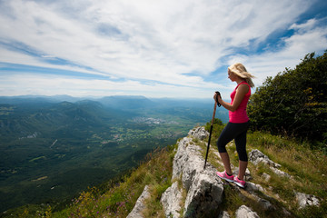Trekking - woman hiking in mountains on a calm sumer day