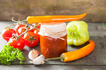 tomato sauce adjika and vegetables on a table, selective focus