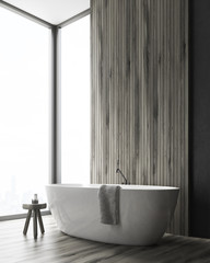 Corner of a bathroom with a tub and a wooden wall
