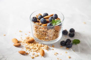 muesli with almonds and blueberry in a glass on a table, selective focus