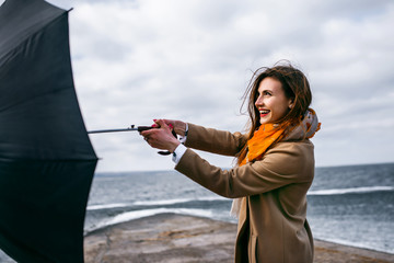 Redhead girl with umbrella by the sea