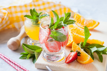 drinks with strawberry and orange in a glass on a table, selective focus
