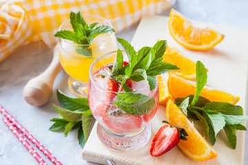 drinks with strawberry and orange in a glass on a table, selective focus