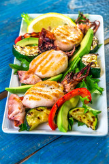 Grilled squids with vegetable on wooden background