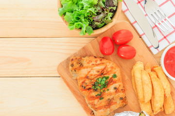 Grilled meat steak serve with tomato sauce, Mashed Potatoes, french fries and vegetable salad, isolated on wooden background, Top view with copy space and text.