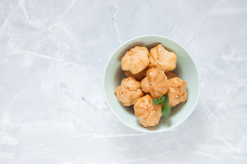 Profiteroles, choux with a cream,  whipped cream, dessert on a plate, selective focus