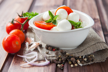 caprese salad: tomato, mozzarella and basil leaves, selective focus
