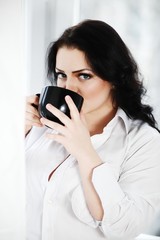 Portrait of young woman drinking a cup of coffee.