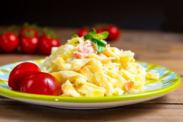 close-up of plate of pasta and smoked salmon with tomato
