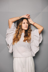 Fototapeta premium Young beautiful woman posing in white dress