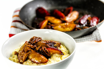 Rice pudding with plums and nuts. Frying plums in pan