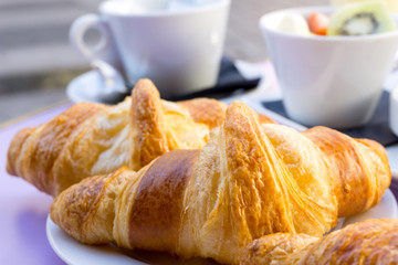Breakfast with coffee and croissants on table