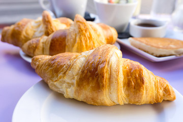 Breakfast with coffee and croissants on table